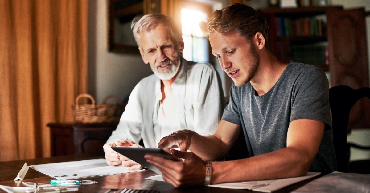 son using tablet with father