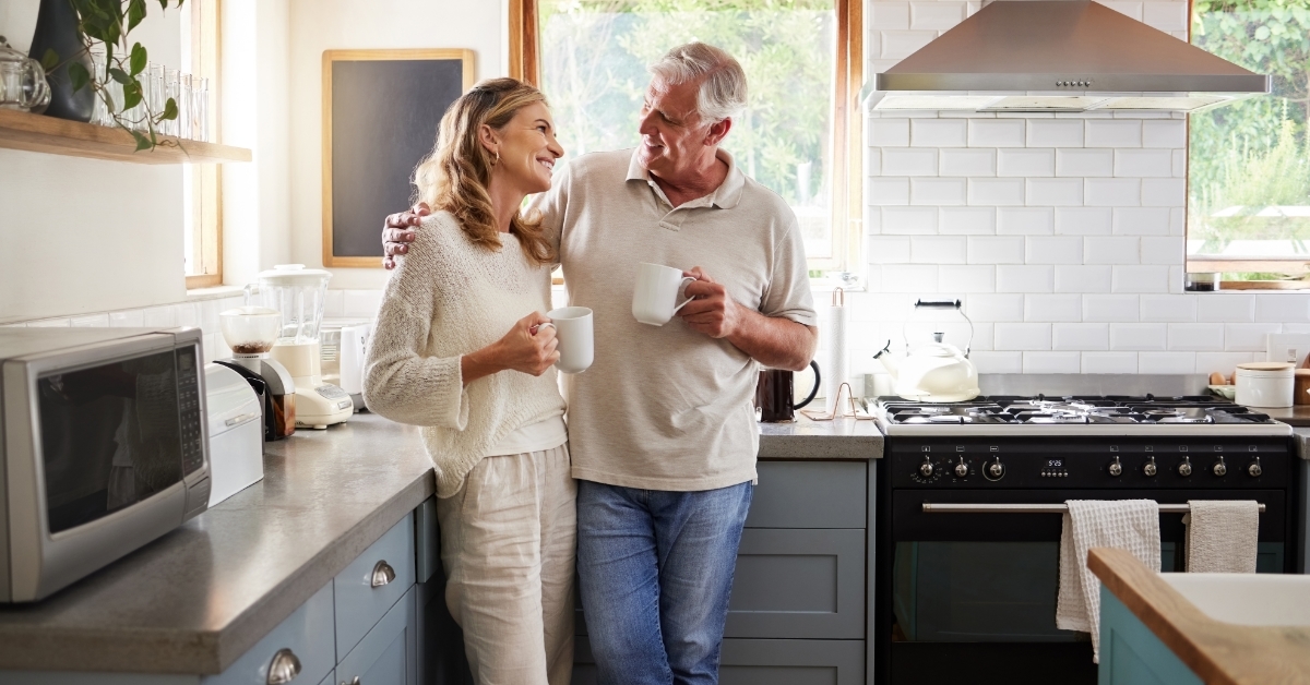 senior couple drinking coffee in kitchen