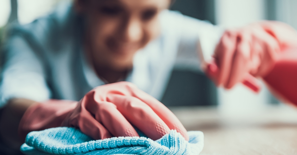 woman cleaning house using gloves