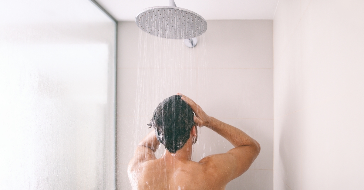 man washing hair while taking shower