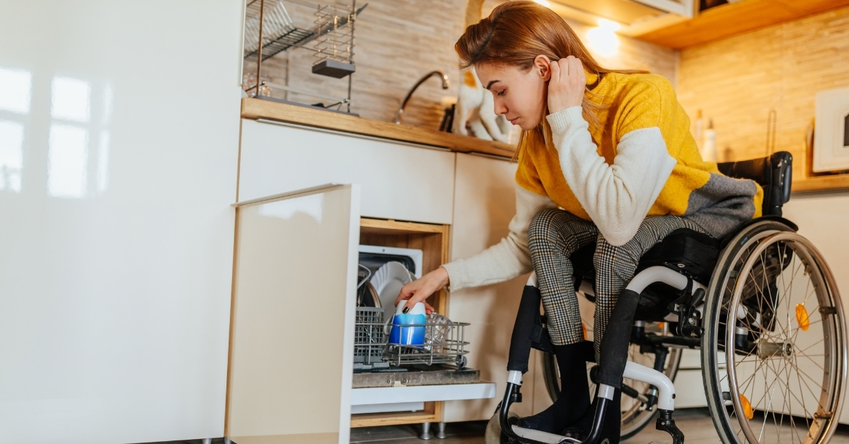 Woman in wheelchair unloading dishwasher