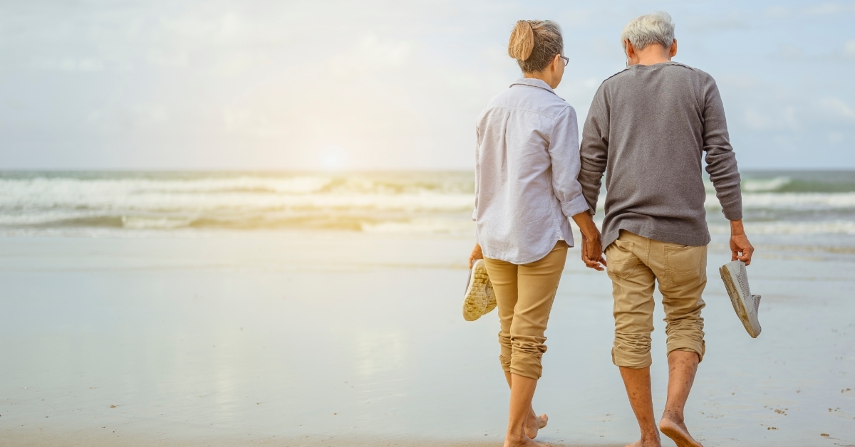senior couple walking on beach