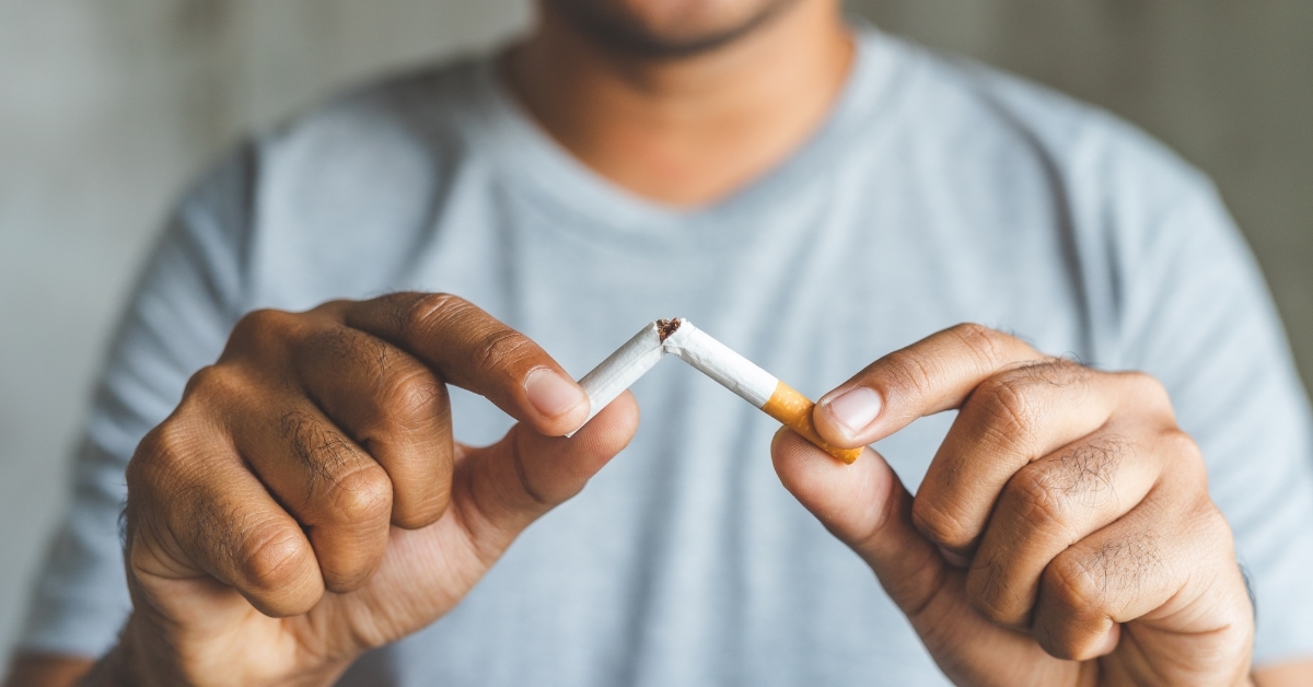 man breaking cigarette in half