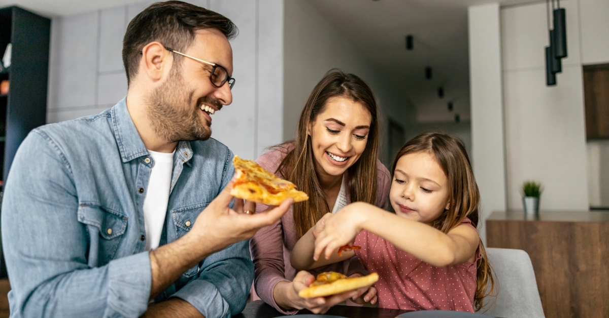 Happy family eating pizza at home
