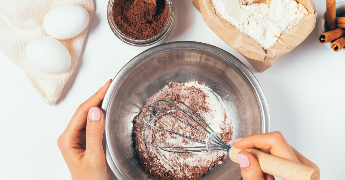 Woman whisking flour cocoa powder bowl