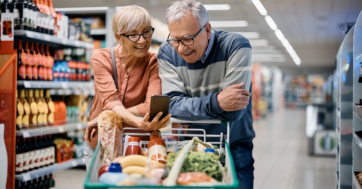senior couple using smartphone while shopping