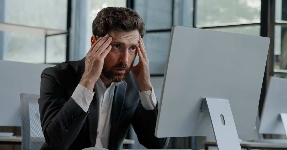 upset businessman in front of laptop