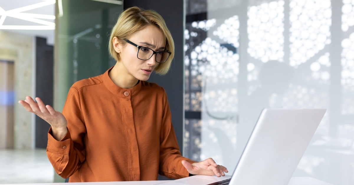 upset woman at workplace using laptop