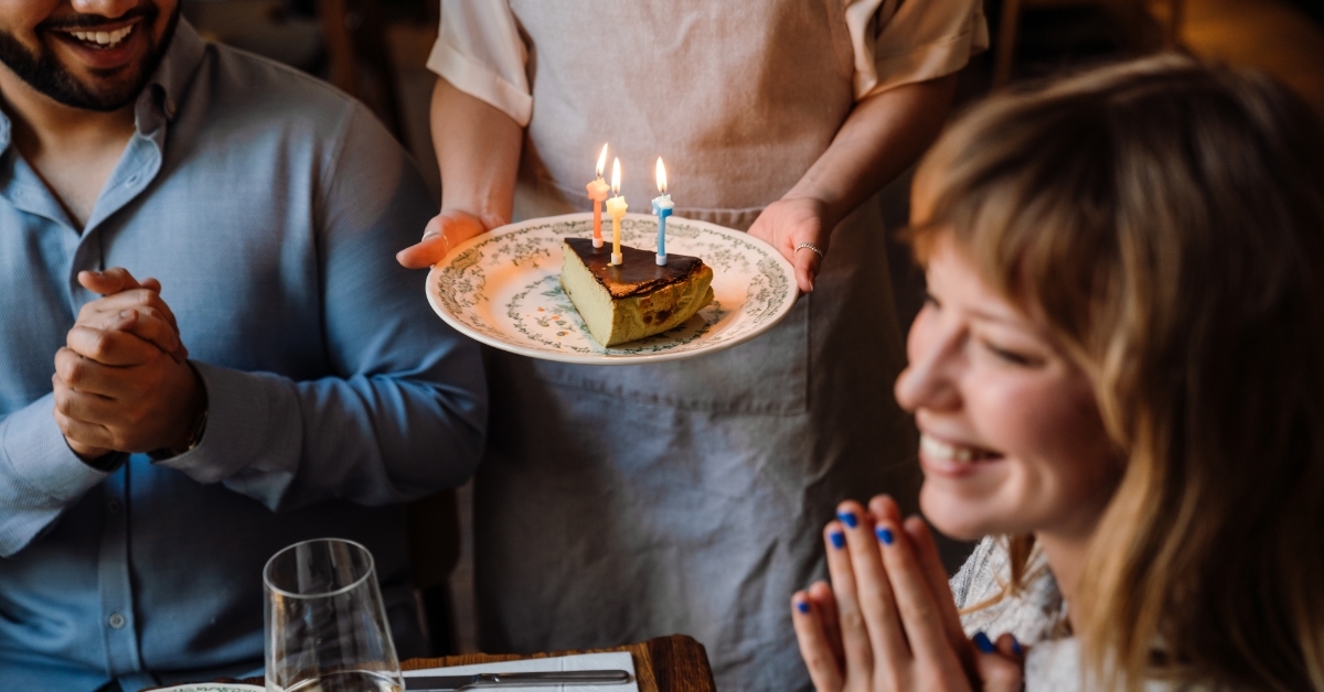 cheerful woman celebrating birthday in restaurant