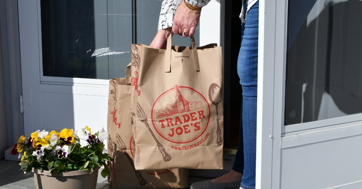 Female recieving Trader Joe's grocery bag