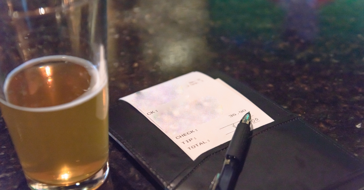 pint glass next to bill holder