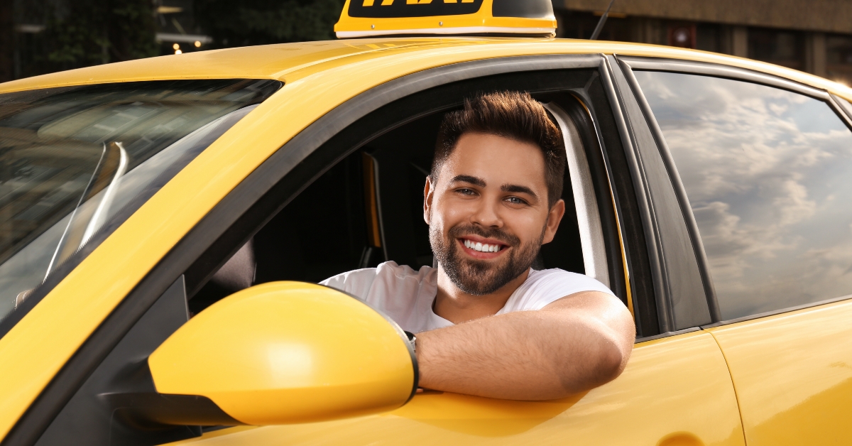 taxi driver in car smiling