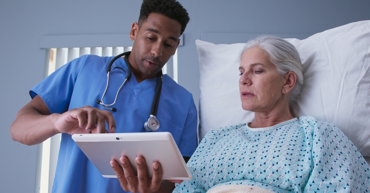 african american nurse showing patient woman tablet