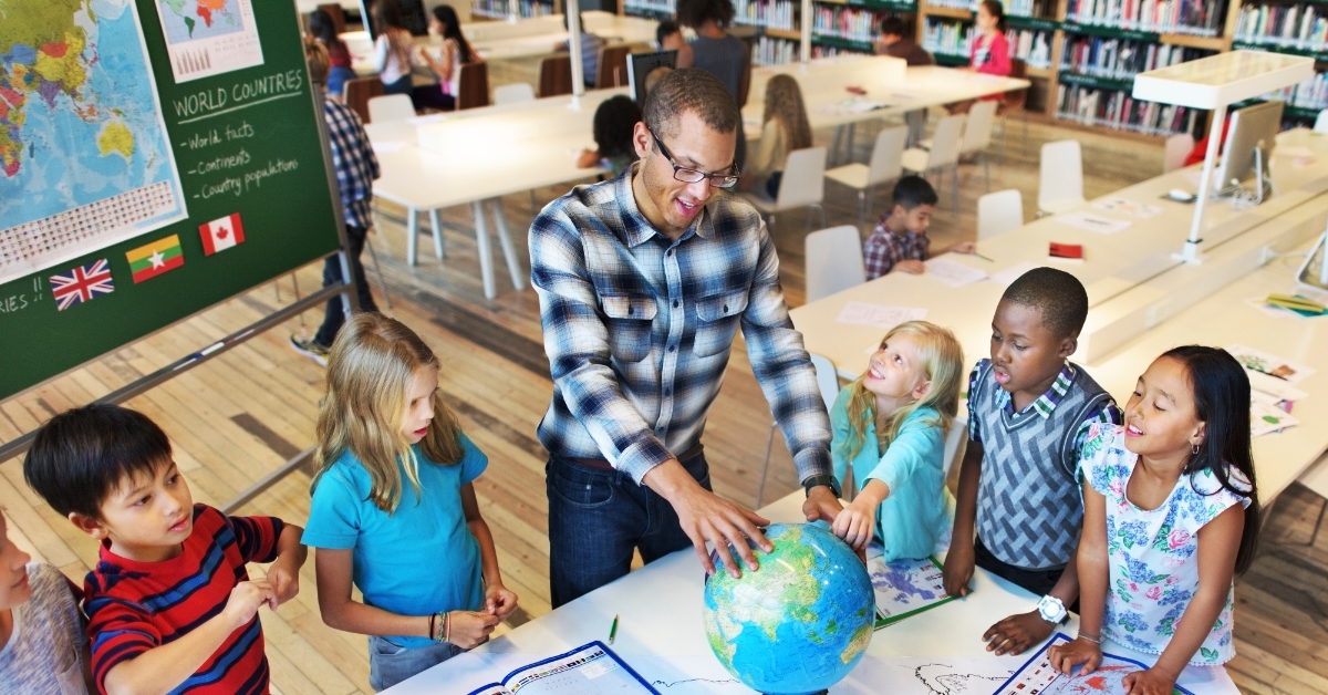 geography teacher teaching students in classroom