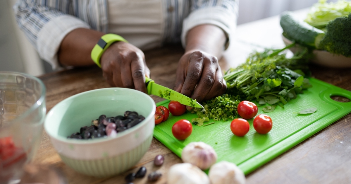 african american housewife cutting vegetables
