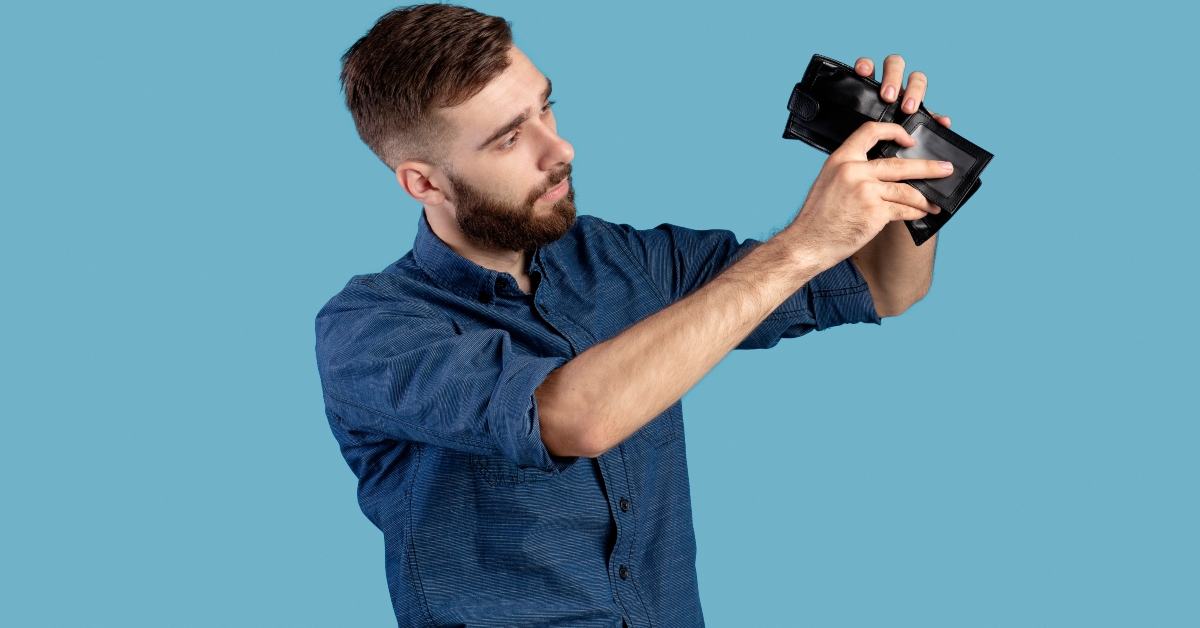 man looking into empty wallet