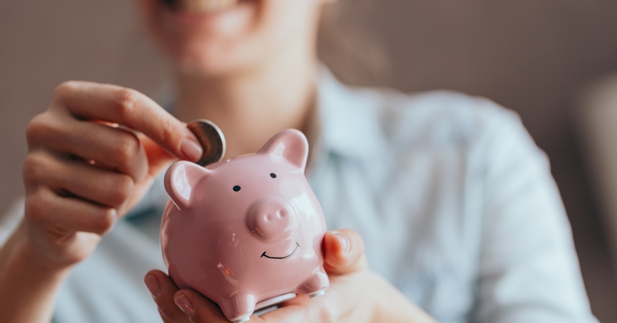 woman saving pennies in piggy bank