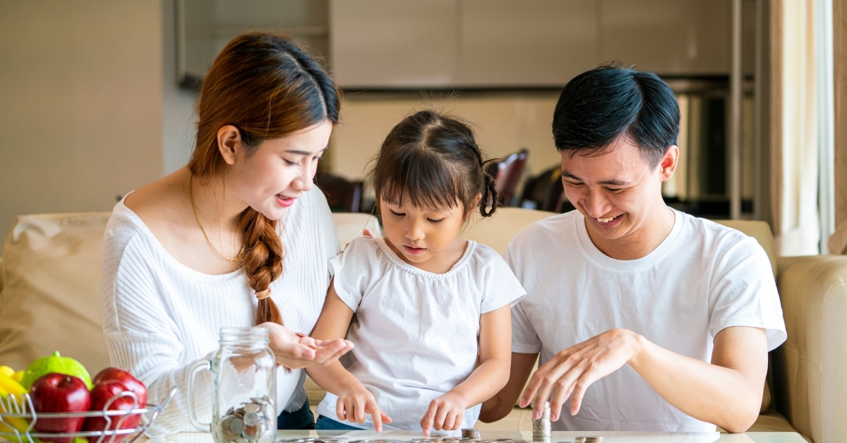 asian family teaching daughter saving money