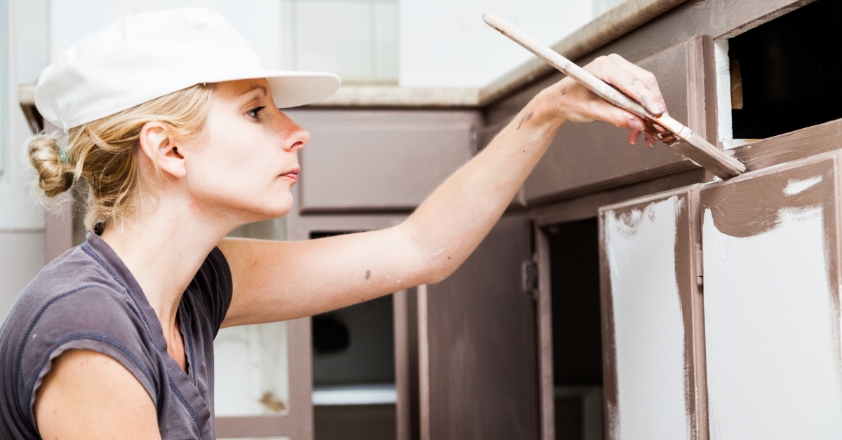 focused Woman Painting Kitchen Cabinets