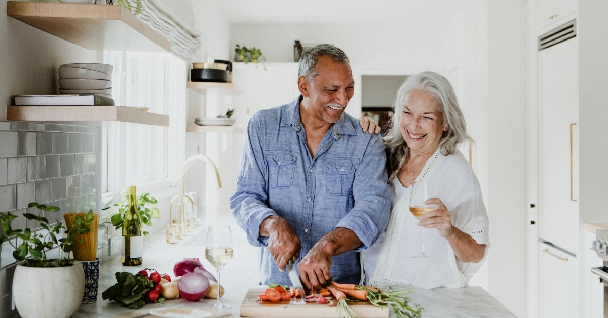 happy senior couple cooking in kitchen