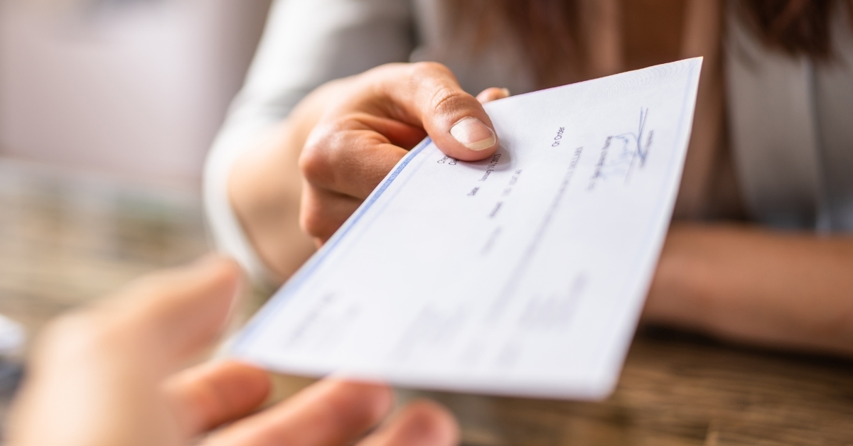 Business woman Giving Cheque To Colleague