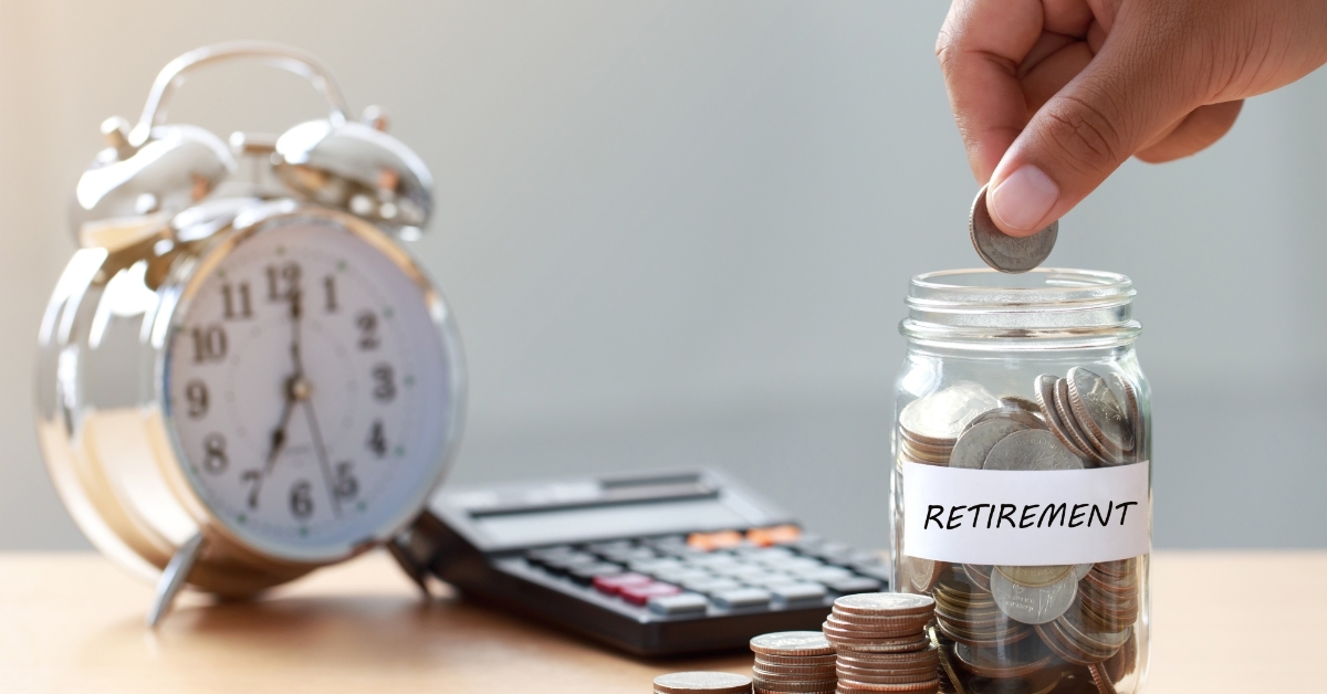 hand putting coins in retirement jar