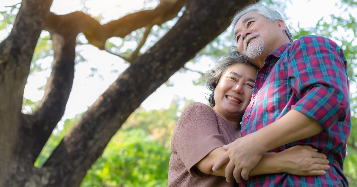 happy retired senior couple hugging outdoors