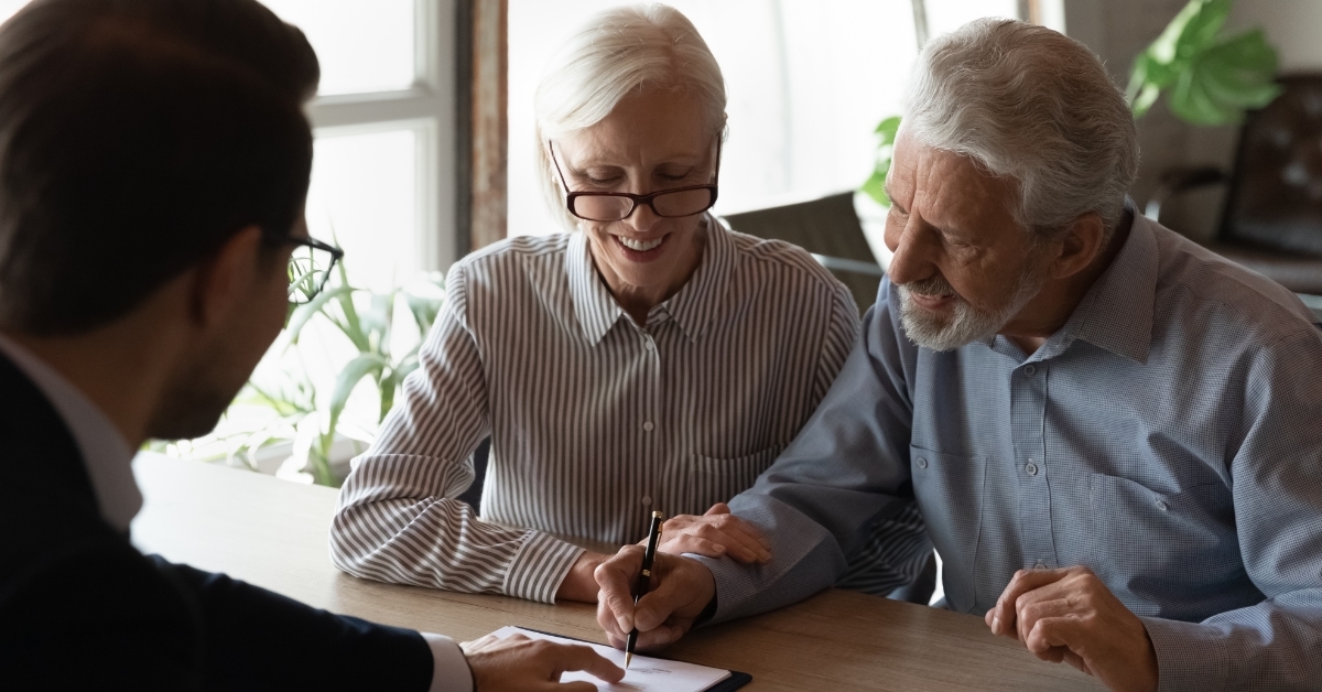 senior couple signing insurance policy 