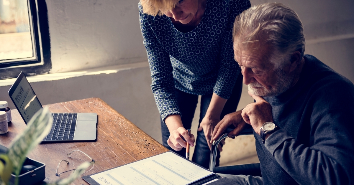 senior man reviewing insurance form on wheelchair