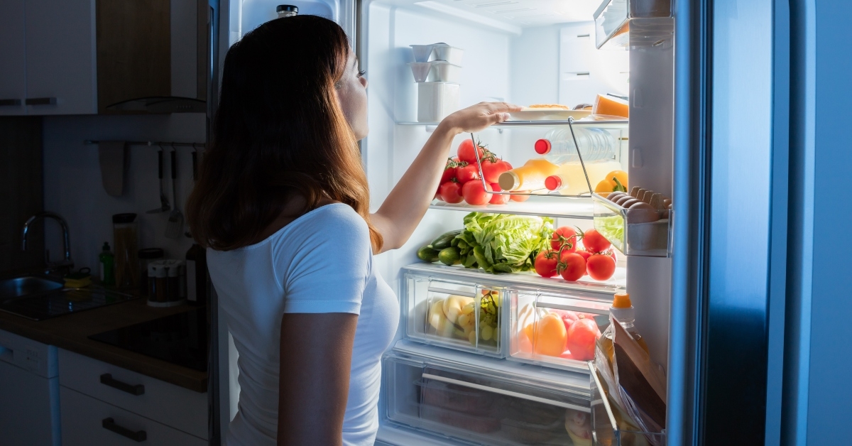 woman looking at food in refrigerator