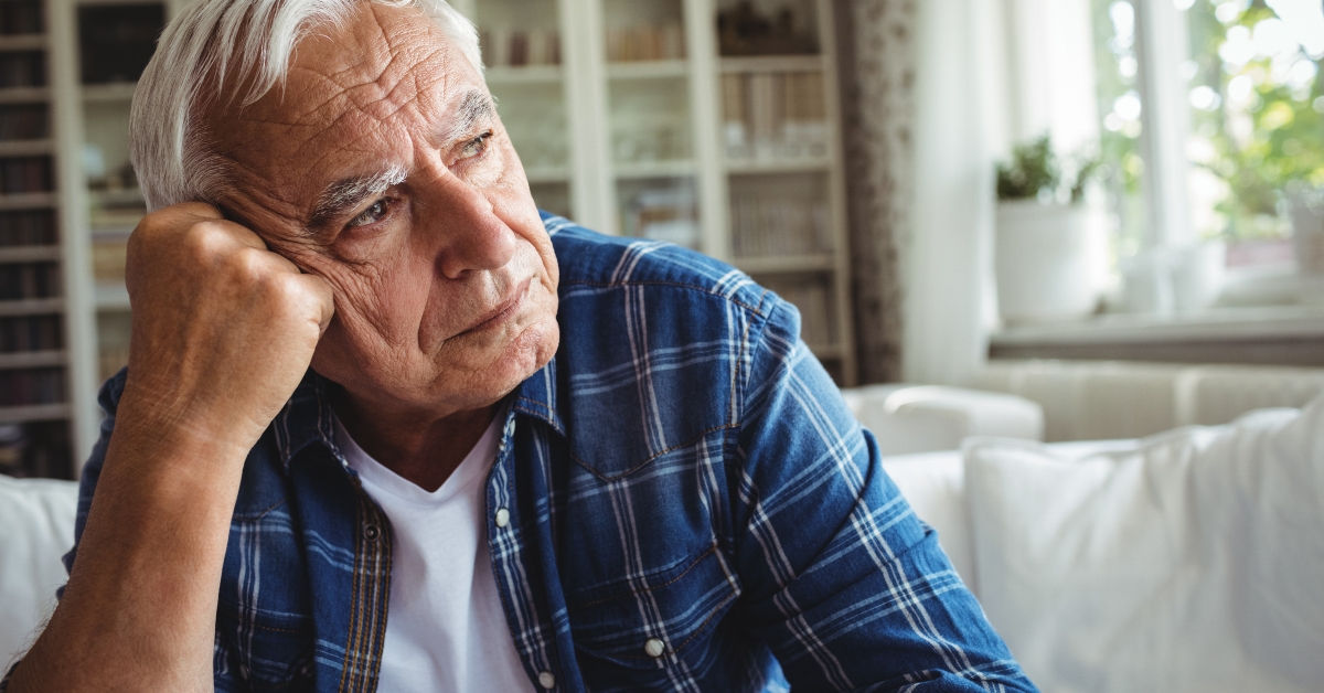 Worried senior man sitting on a sofa
