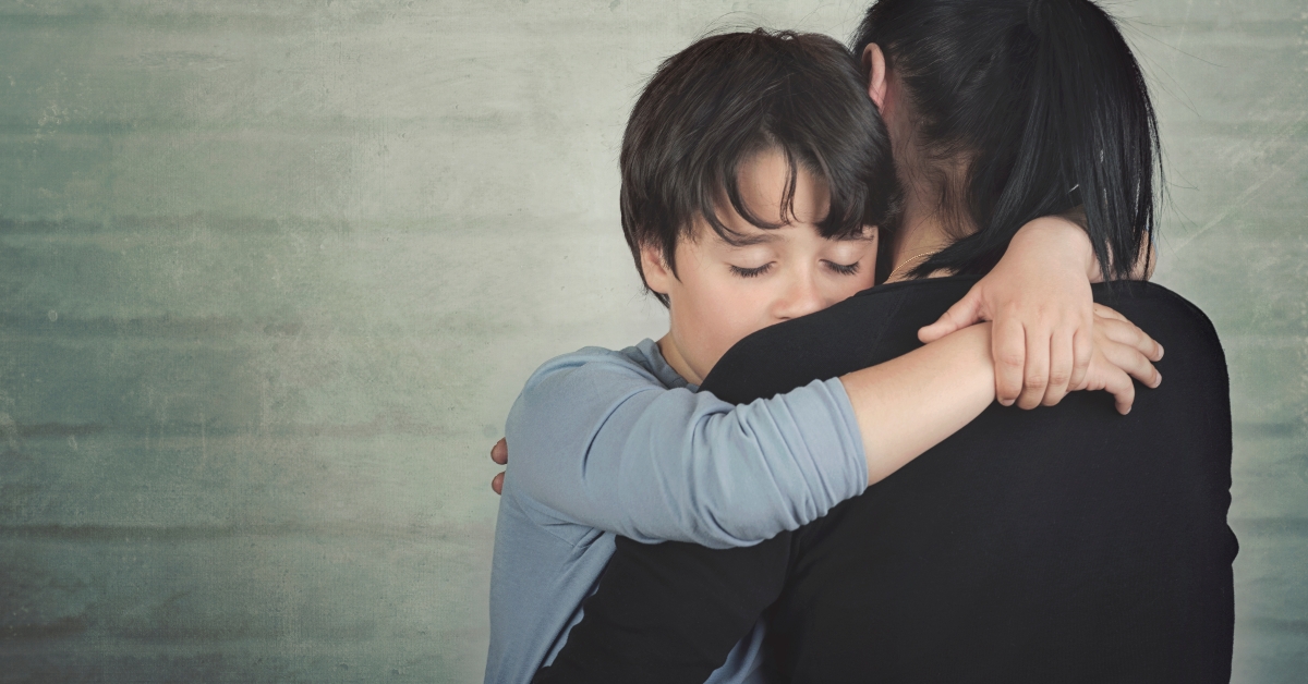 Sad child hugging his mother