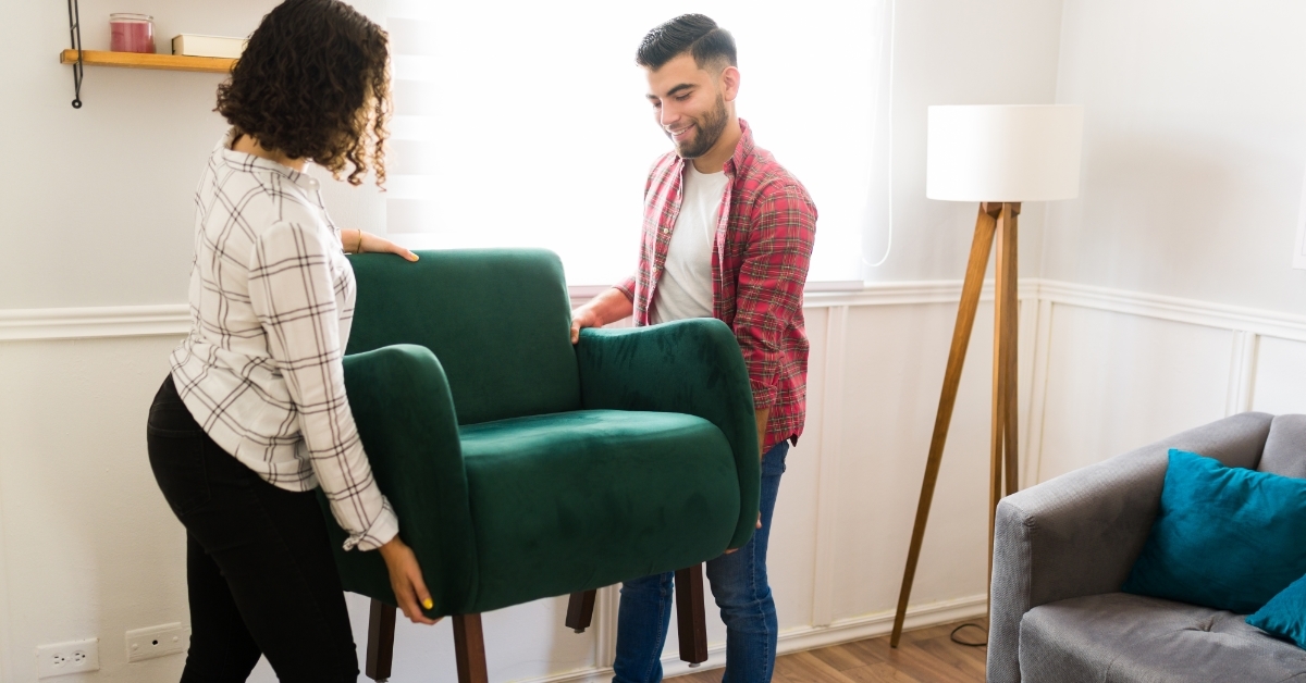 happy couple moving furniture in new house