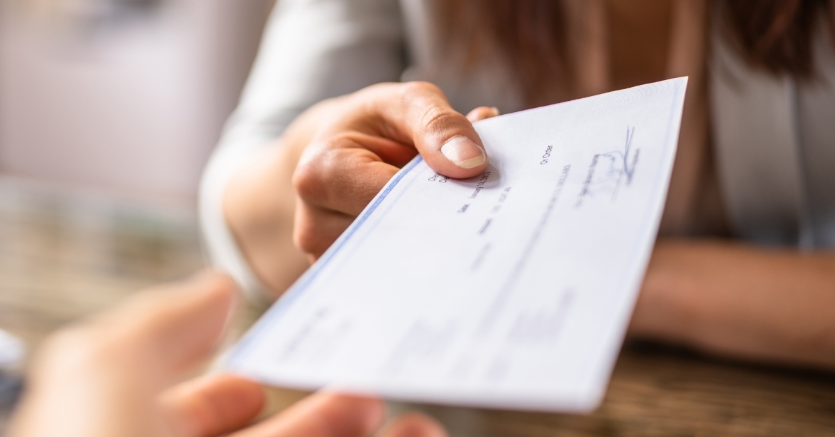 Business woman Giving Cheque To Colleague