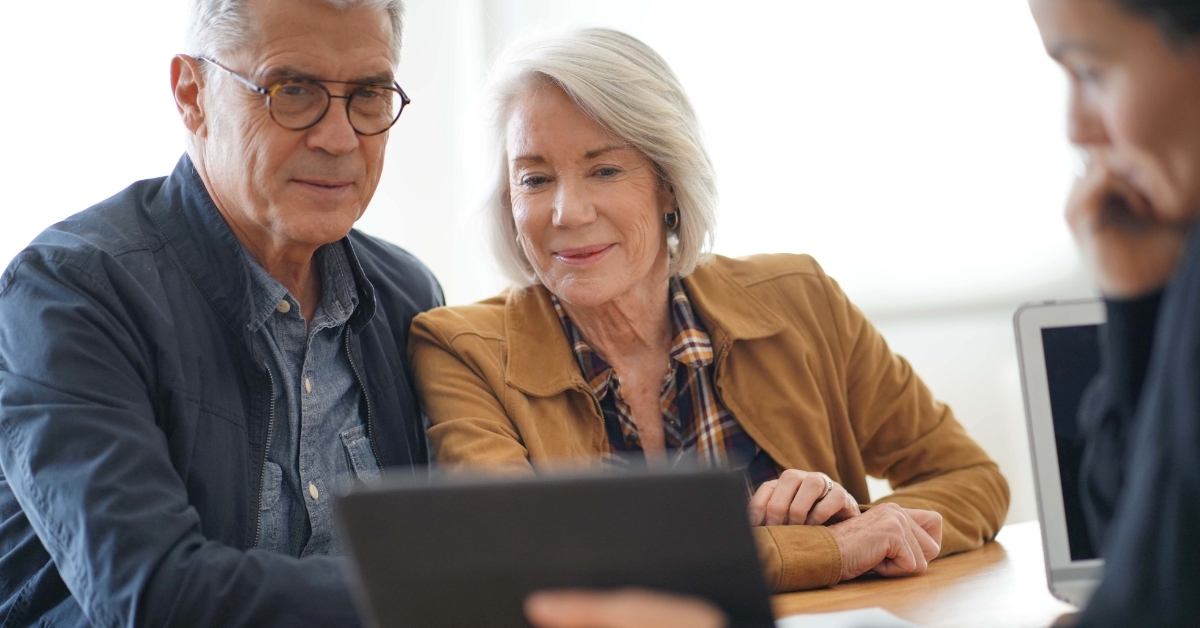 senior couple checking insurance policy on tablet