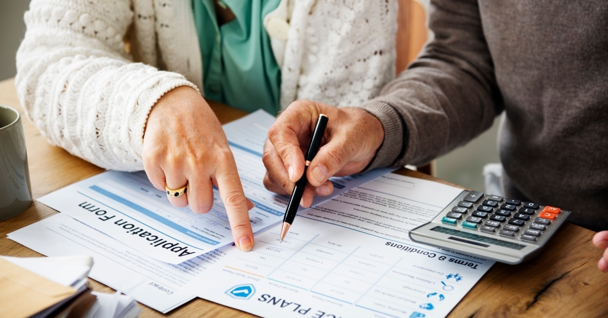 senior couple signing insurance policy