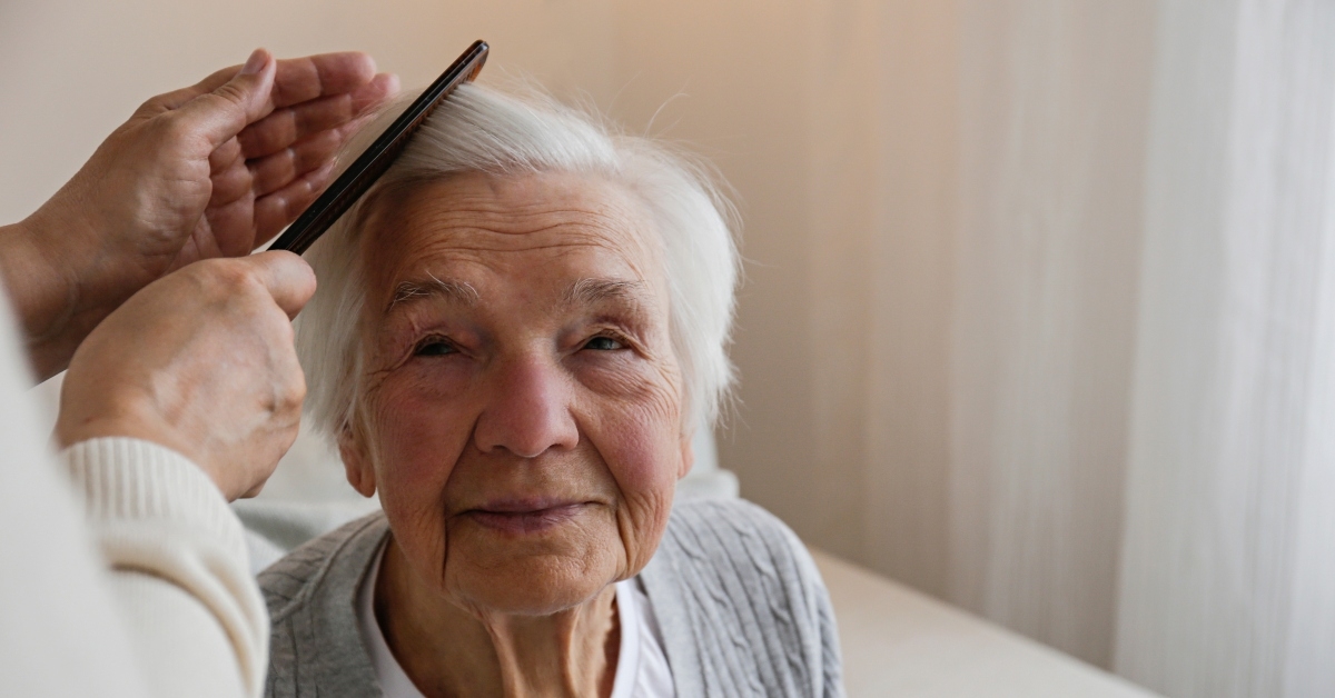 brushing hair of an elderly lady