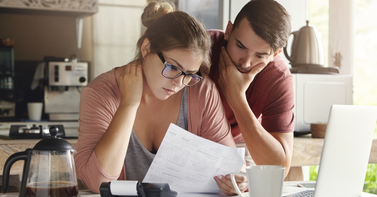 depressed couple reviewing bills together