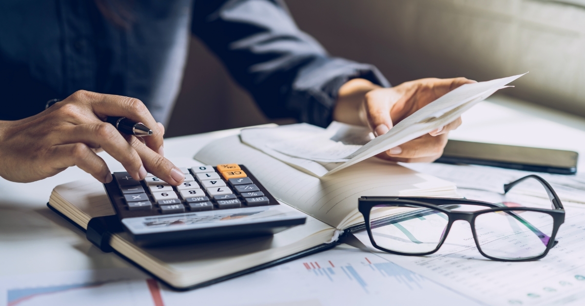 stressed man reviewing bills using calculator