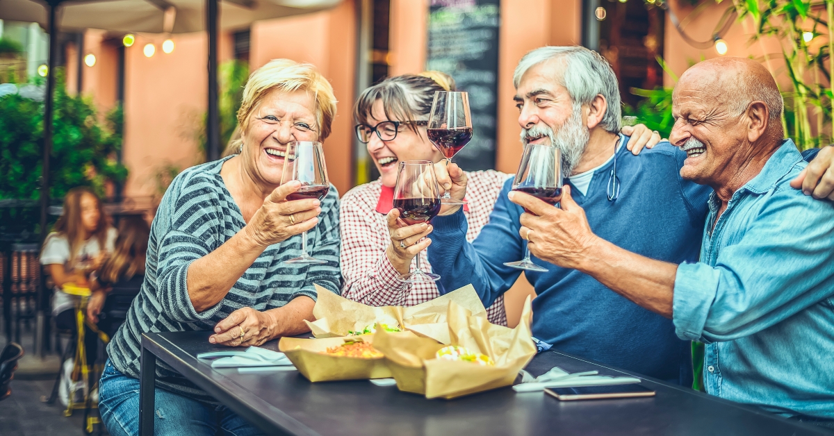 happy elderly friends toasting