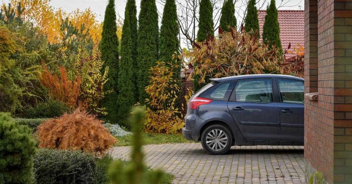 car parked near garage besides garden