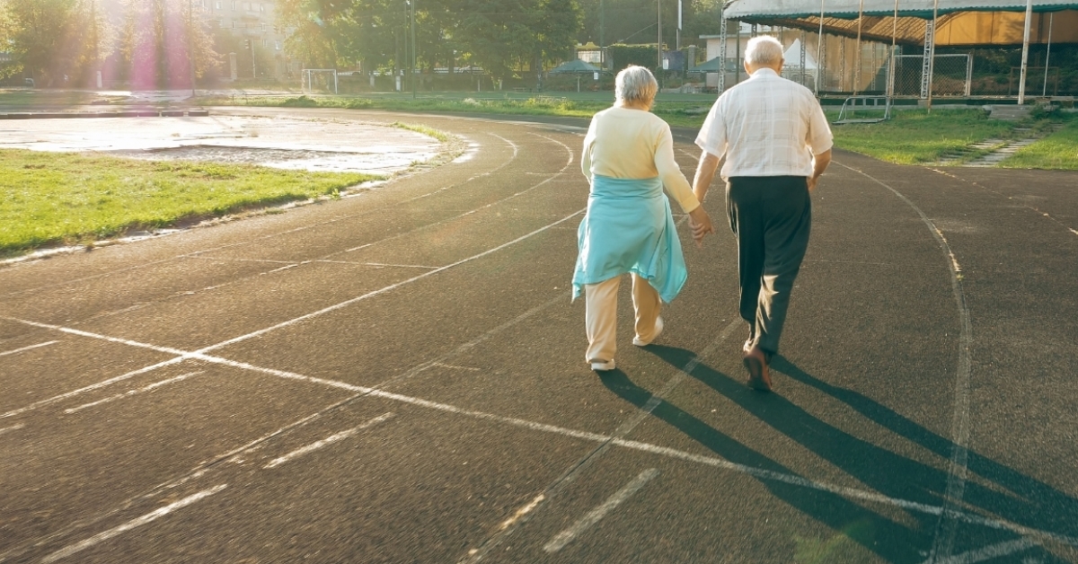 senior couple walking on running track