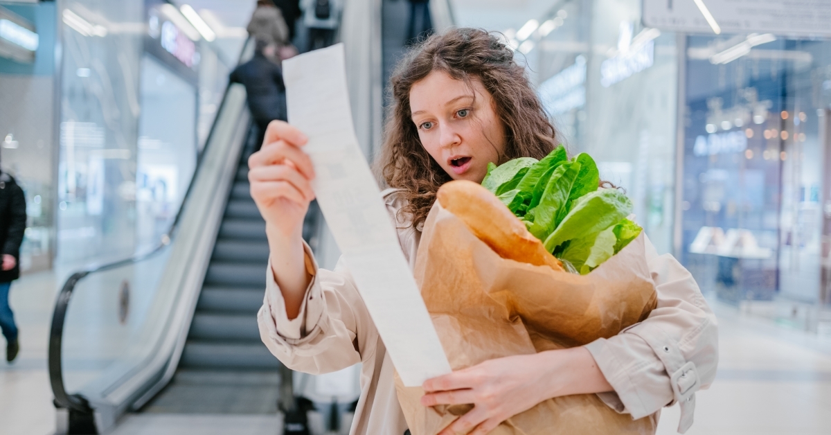 shocked woman reading grocery receipt