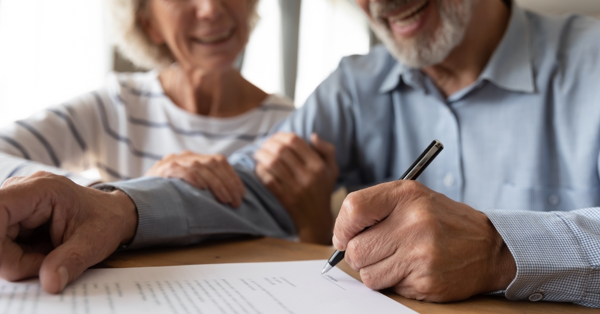 happy senior couple sogning iinsurance policy