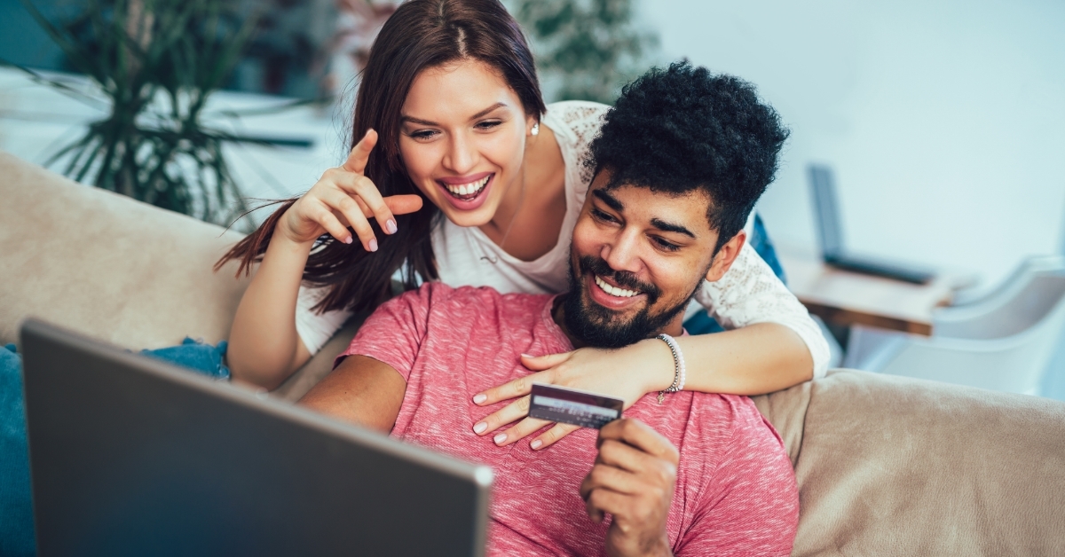 happy couple shopping online on laptop