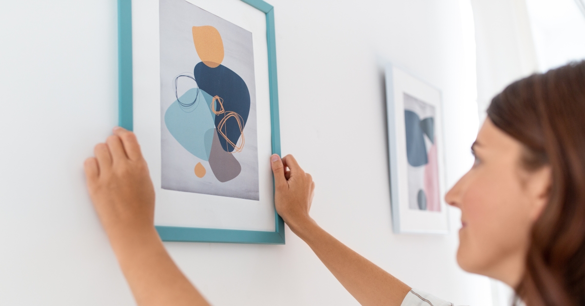 woman hanging picture