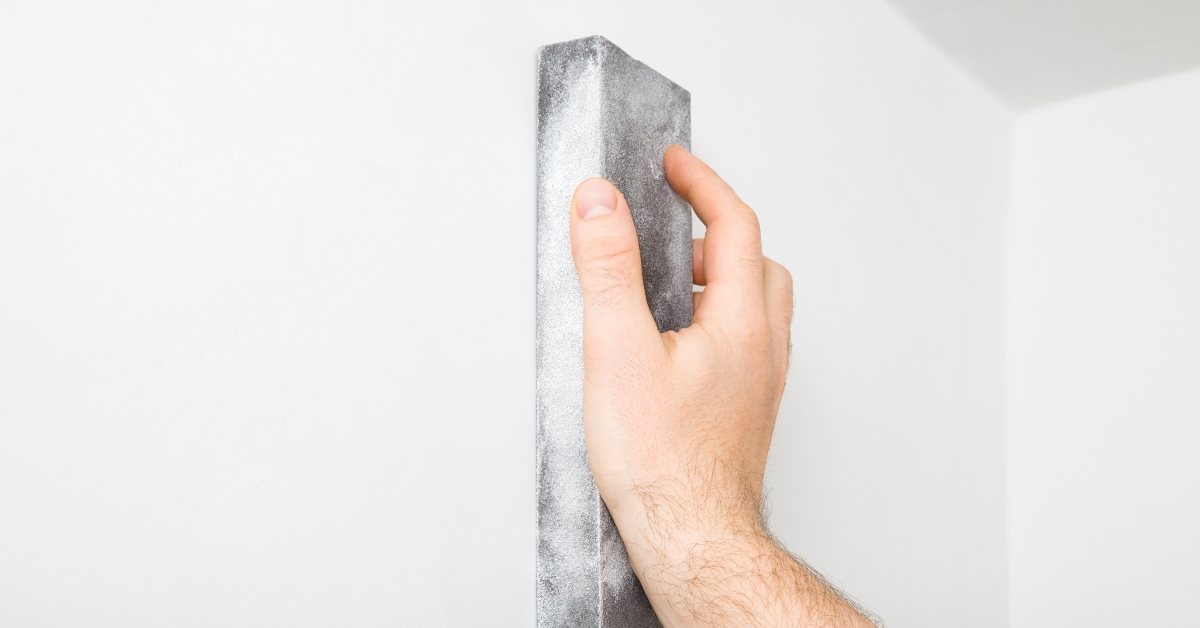 Worker hand polishing white wall