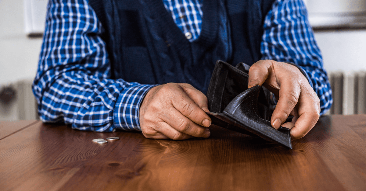 senior man showing an empty wallet without money