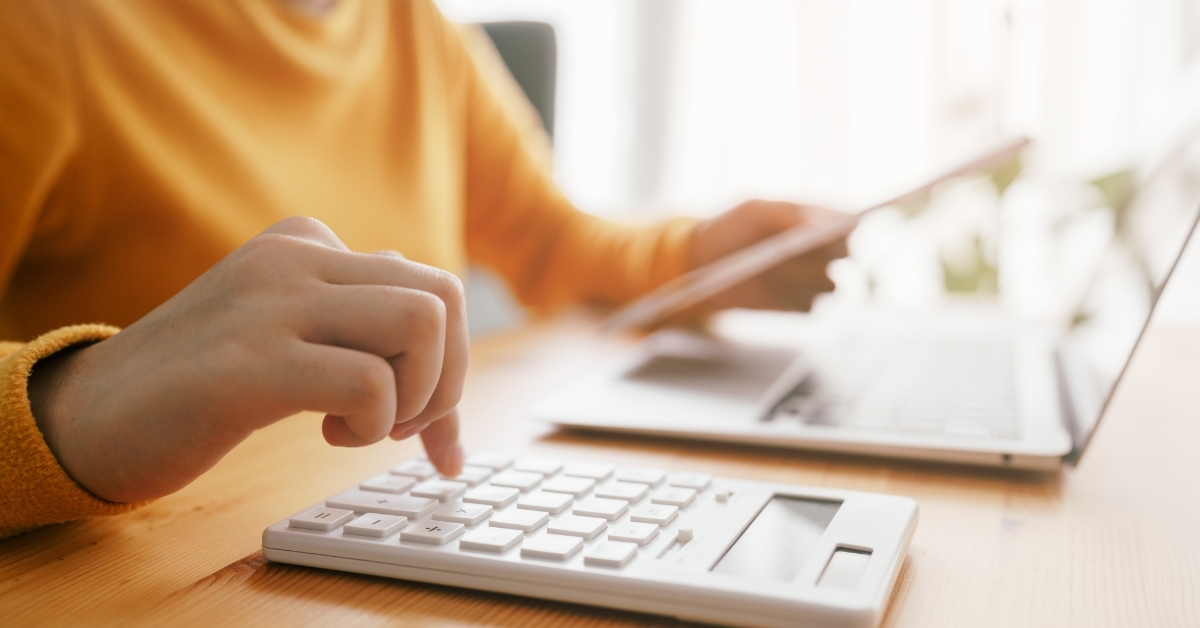asian woman calculating bills using calculator