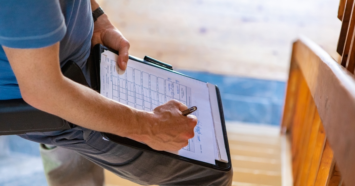 engineer making notes while inspecting home